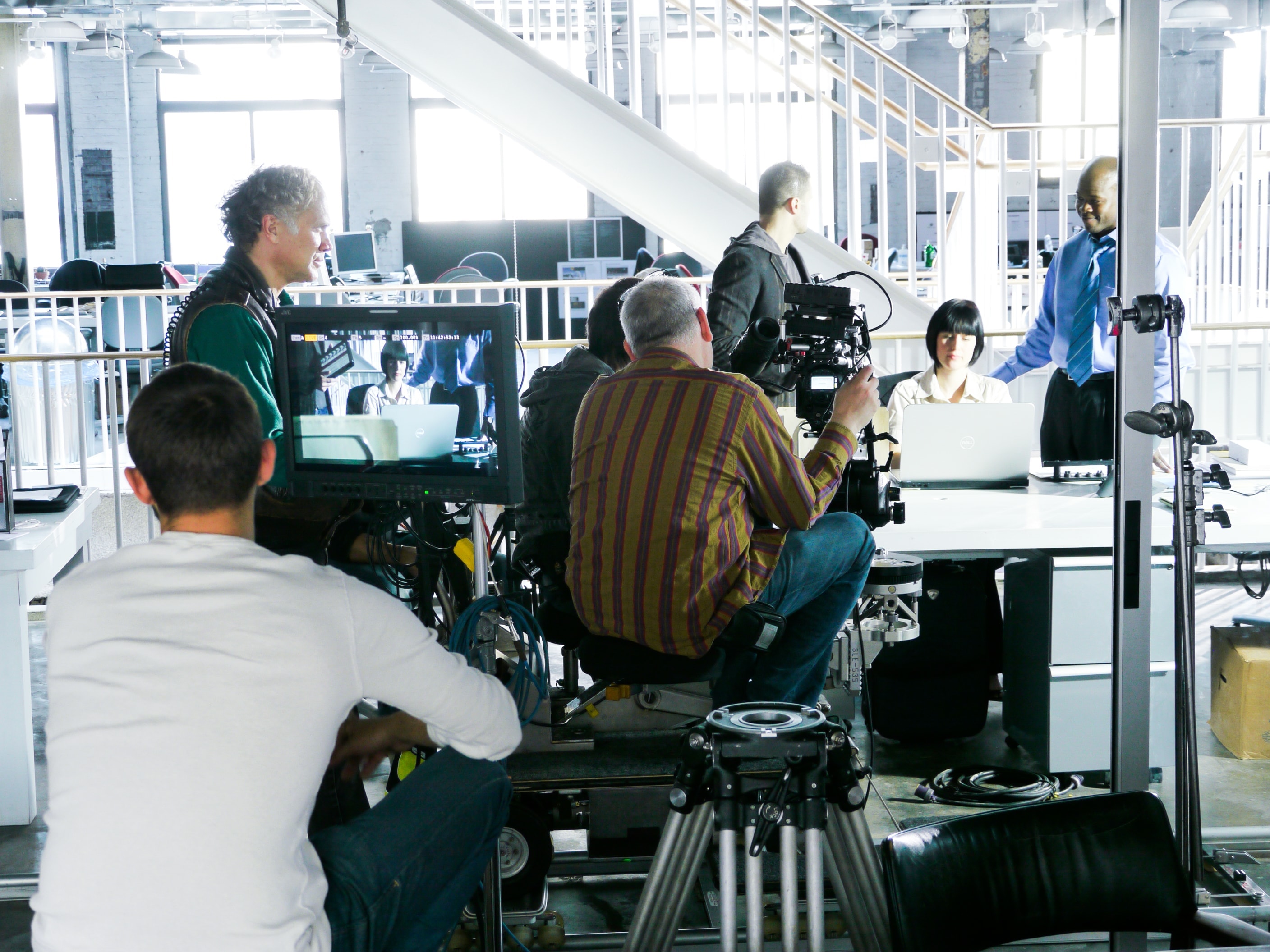 Film crew recording a scene in a bright studio workspace
