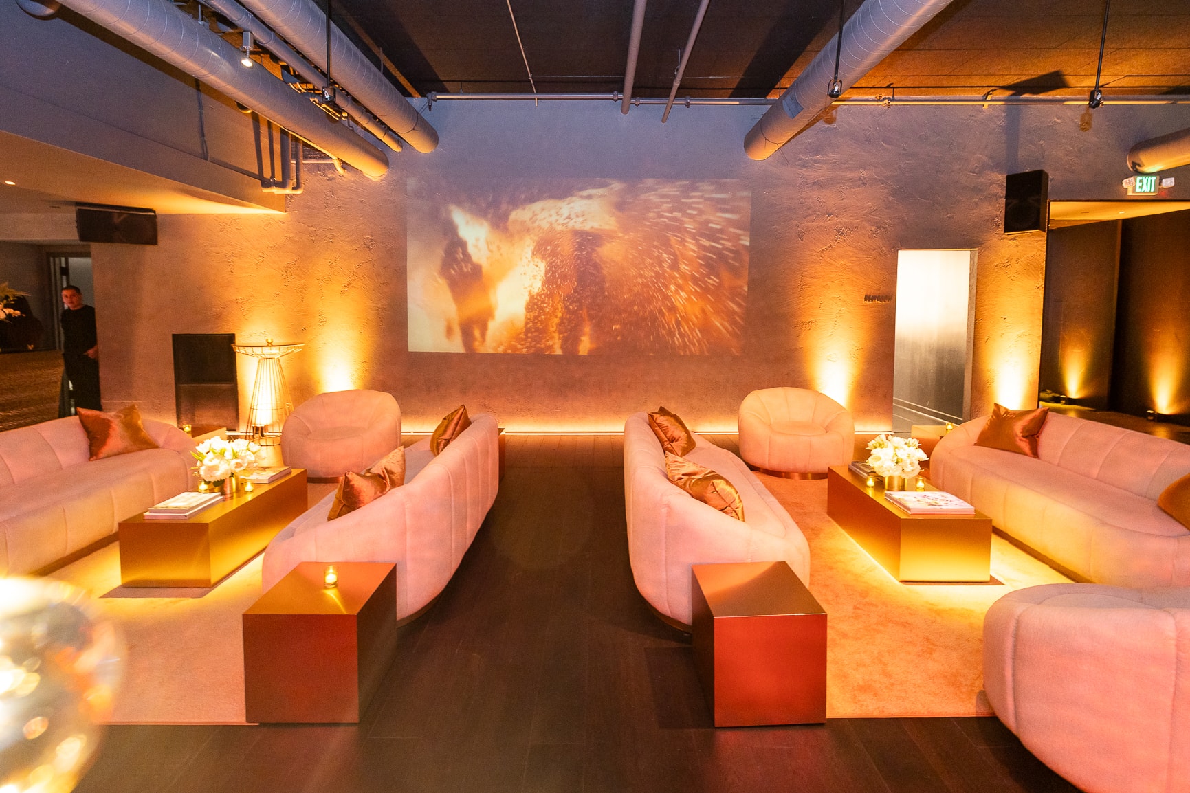 Modern lounge with pink seating and projection screen