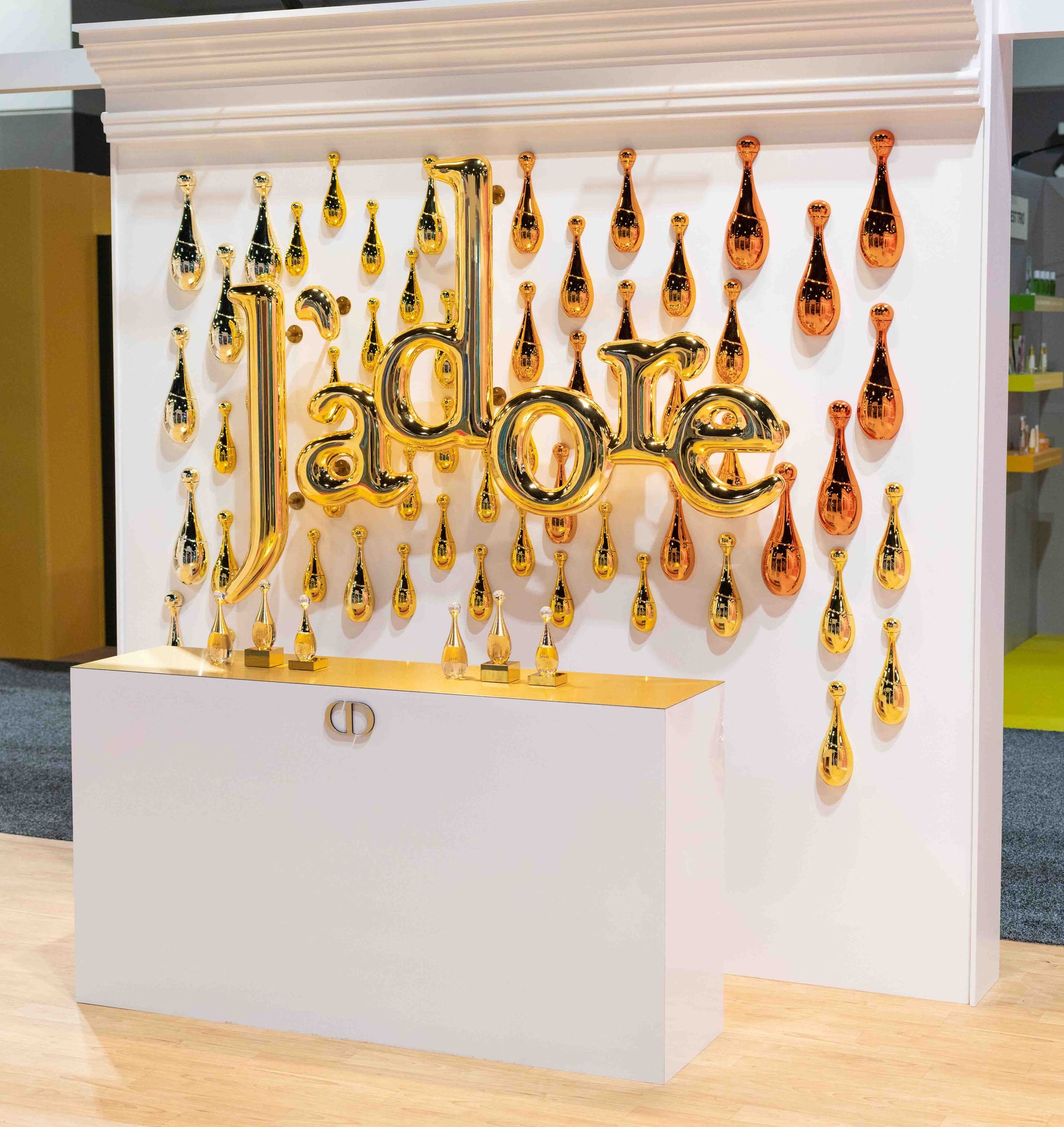 Gold Dior logo display with perfume bottles