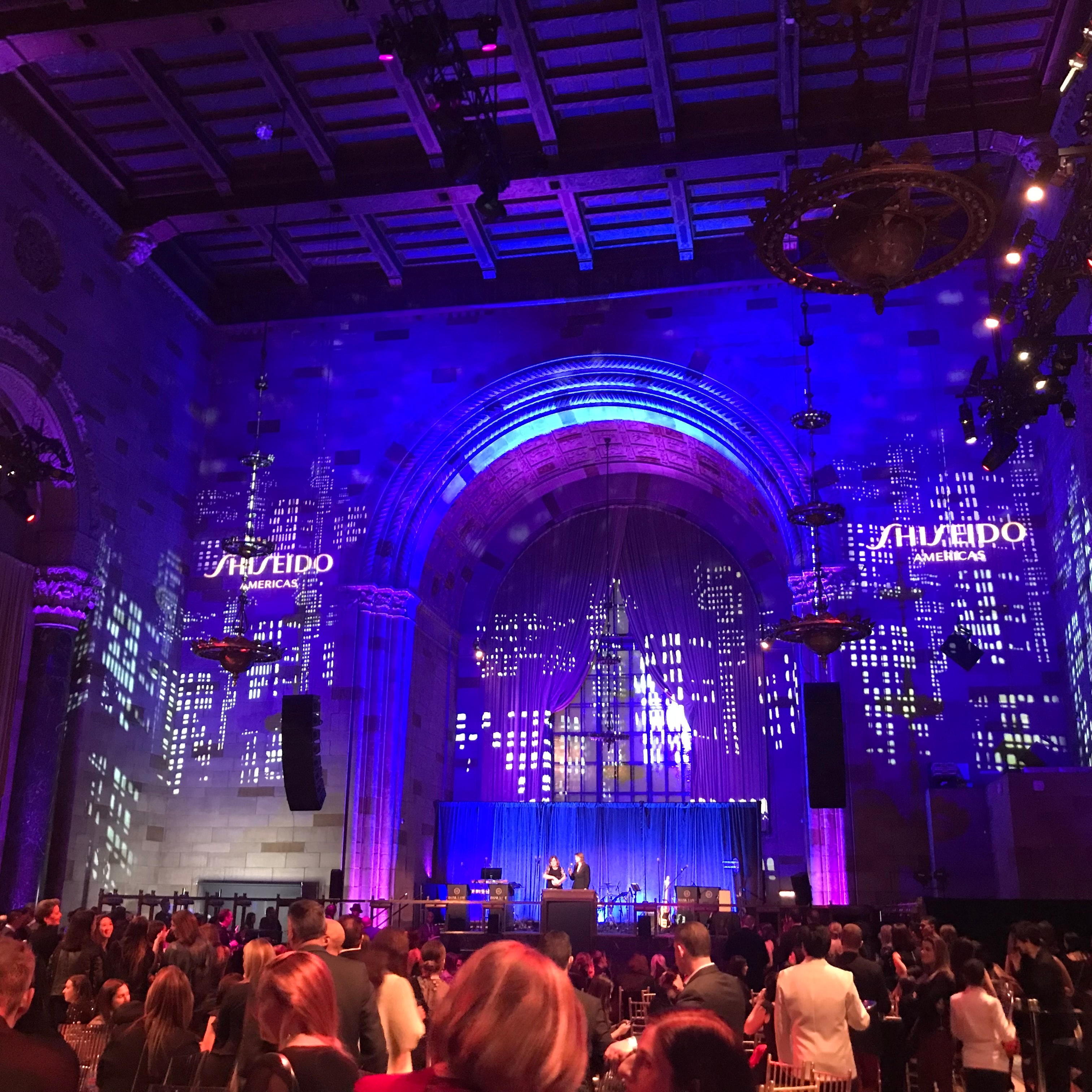 Blue-lit event stage with seated audience