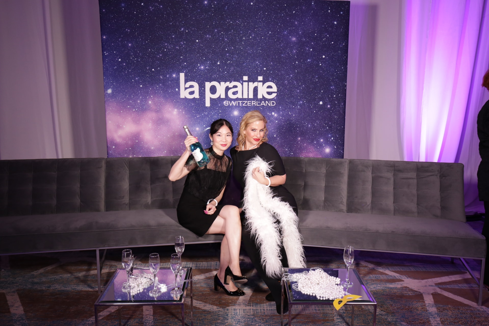 Women posing with dog at luxury event
