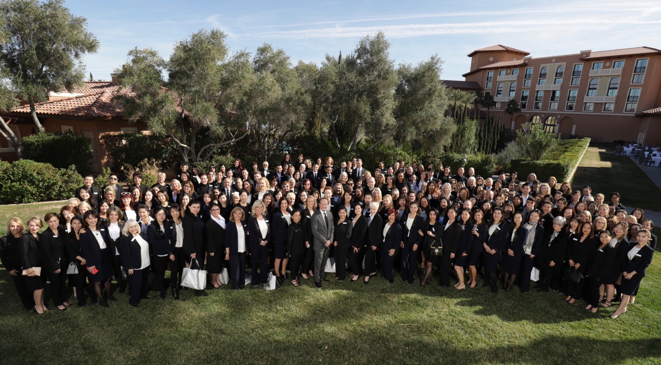 Large group posing outside resort building