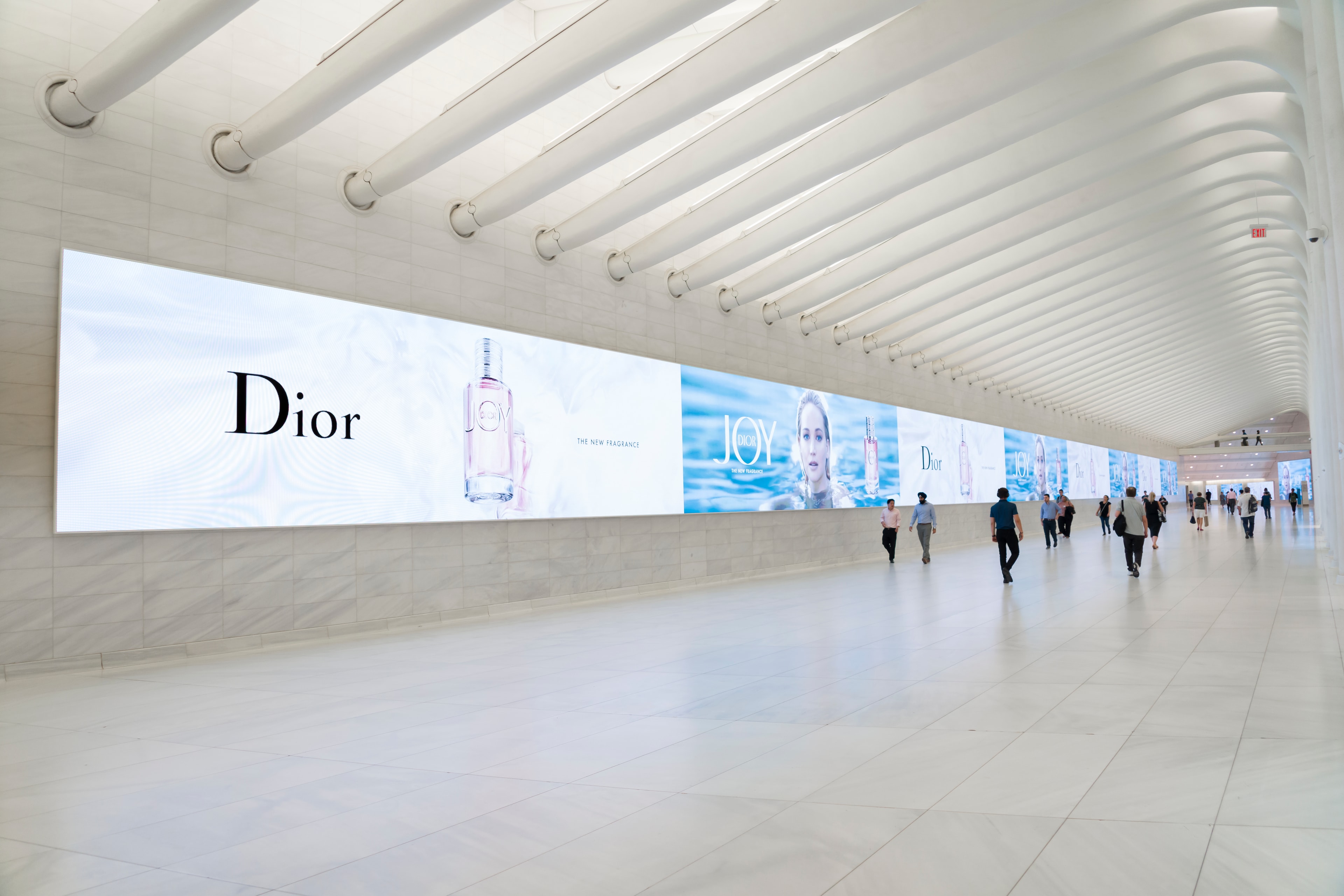 Travelers walking through an airport corridor display