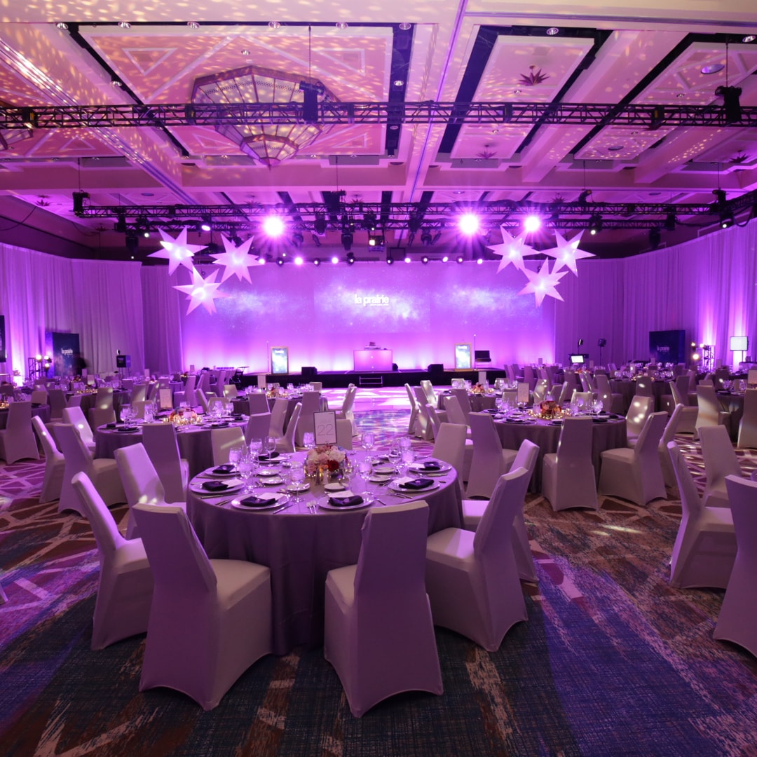 Purple-lit banquet hall with decorated tables